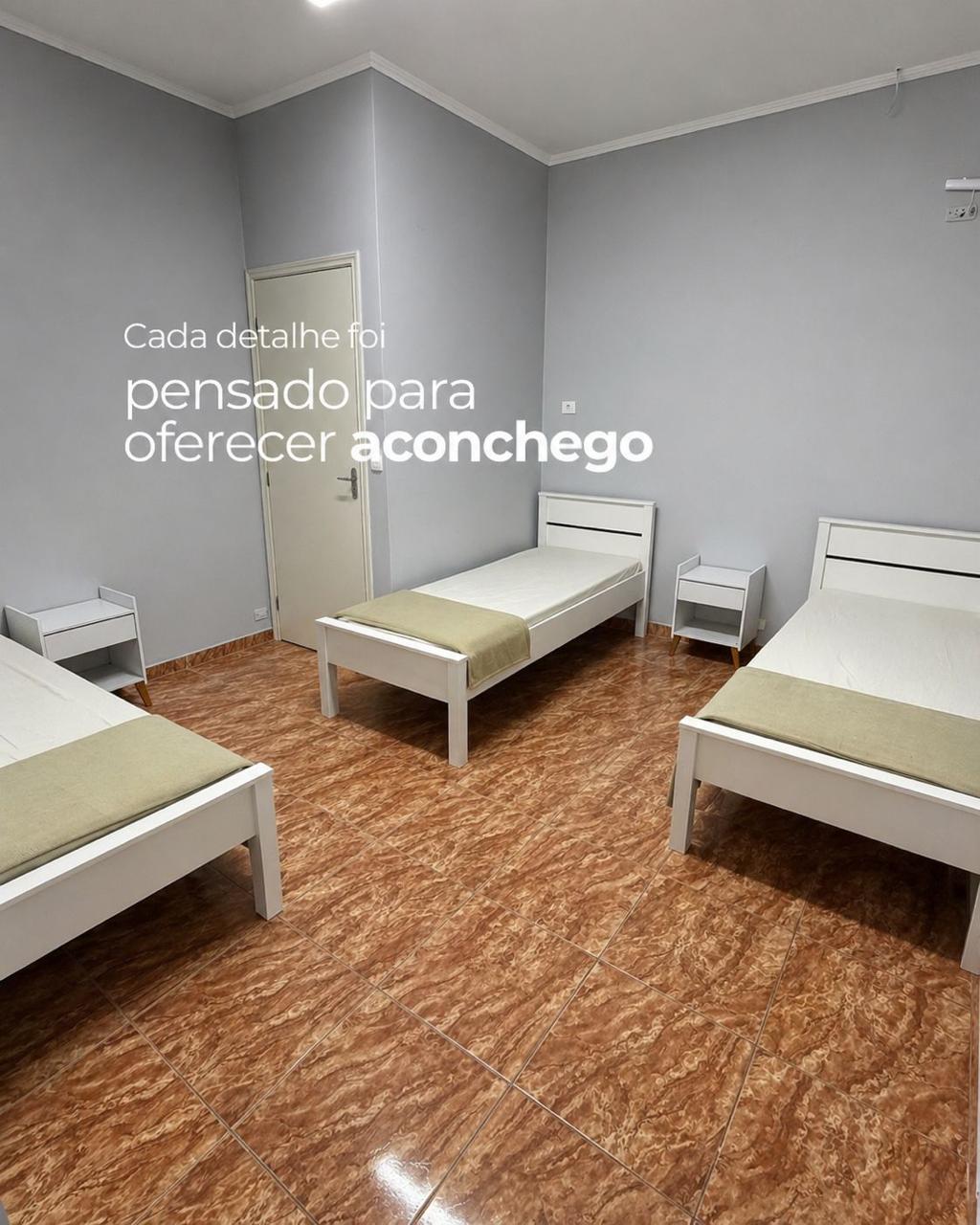 Quarto compartilhado com camas brancas e aconchegantes